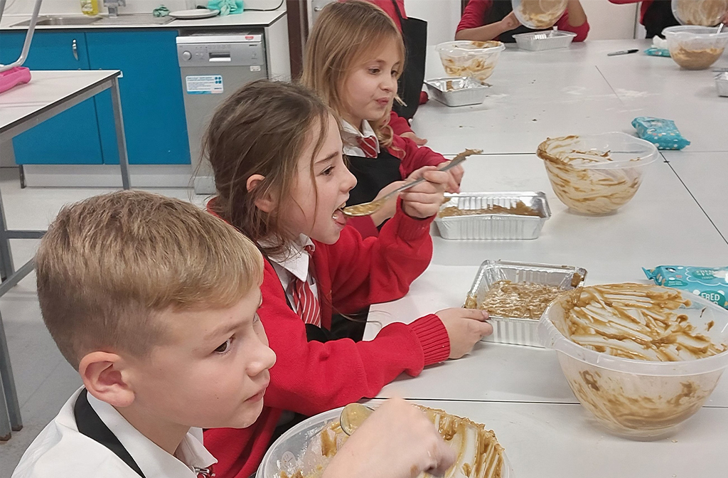 Children at Scott Primary School testing their cake mix in cookery